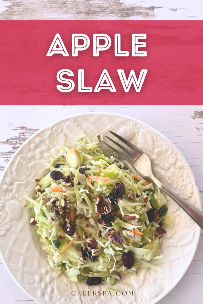 Sweet & Tangy Apple Slaw – A crunchy, refreshing salad for any occasion. A vibrant plate of Sweet & Tangy Apple Slaw featuring shredded broccoli slaw, cabbage, crisp apple slices, dried cranberries, and crunchy pecans, all tossed in a light apple cider vinaigrette.